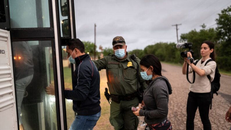 Los inmigrantes ilegales suben a un autobús luego de ser detenidos cerca de la frontera entre México y Estados Unidos en Del Río, Texas, el 16 de mayo de 2021. (Sergio Flores/AFP vía Getty Images)