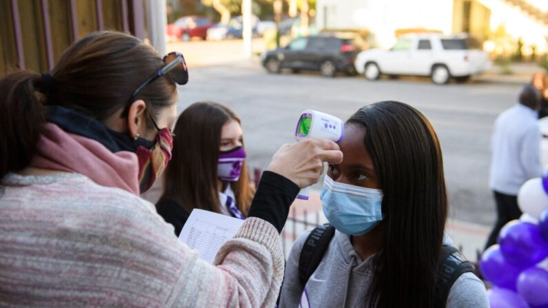 Un estudiante recibe un chequeo de temperatura antes de la clase mientras vuelve al aprendizaje presencial en una foto de archivo. (Patrick T. Fallon/AFP vía Getty Images)