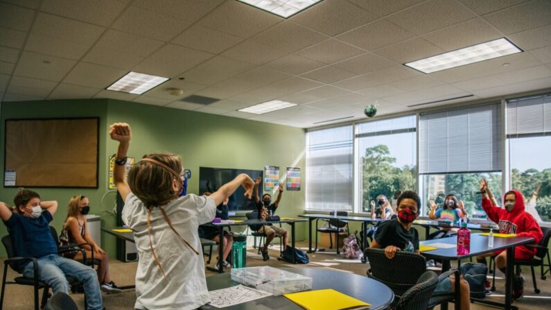 Se ve a los niños usando mascarillas en cumplimiento de una orden en una actividad en clase en la Academia Xavier en Houston, Texas, el 23 de agosto de 2021. (Brandon Bell/Getty Images)