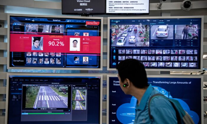 Una pantalla de reconocimiento facial e inteligencia artificial se aprecia a través de los monitores en la sede Bantian de Huawei, en Shenzhen, China, el 26 de abril de 2019. (Kevin Frayer/Getty Images)