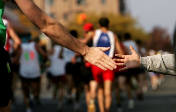 Un joven simpatizante tiende la mano a un corredor durante el Maratón de Nueva York el 6 de noviembre de 2005 en la ciudad de Nueva York. (Spencer Platt/Getty Images)