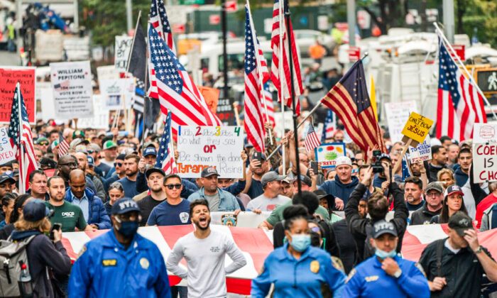 Manifestantes marchan por el puente Brooklyn de Nueva York en protesta contra la orden de vacunación COVID-19 para los trabajadores municipales de la ciudad el 25 de octubre de 2021. (David Dee Delgado/Getty Images)