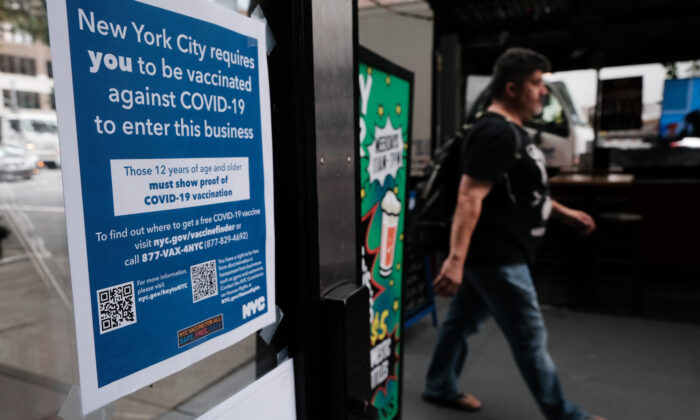 Un letrero en la ventana de un restaurante informa a los clientes que deberán mostrar una prueba de que han recibido una vacuna anti-COVID para poder ingresar, en la ciudad de Nueva York, el 20 de agosto de 2021. (Spencer Platt/Getty Images)