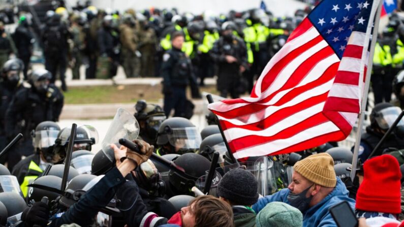 Manifestantes luchan con la policía antidisturbios frente al edificio del Capitolio en Washington el 6 de enero de 2021. (Roberto Schmidt/AFP vía Getty Images)