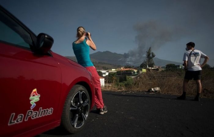 La gente observa el volcán Cumbre Vieja arrojando lava, ceniza y humo de El Paso, en la isla canaria de La Palma el 2 de octubre de 2021. (JORGE GUERRERO/AFP vía Getty Images)