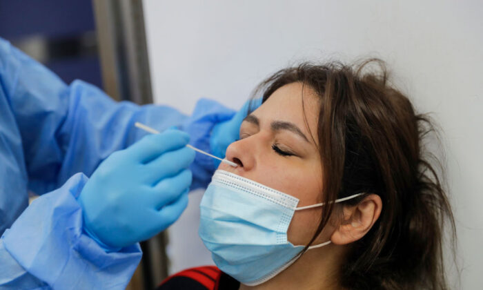 Un trabajador sanitario administra una prueba de PCR a una mujer en la unidad de cuidados intensivos del Hospital Universitario Rafic Hariri en Beirut, la capital libanesa, el 5 de enero de 2021. (Joseph Eid/AFP vía Getty Images)