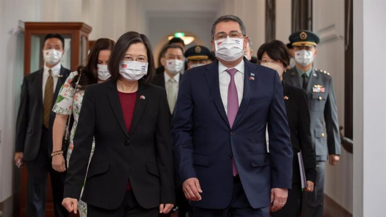 Una foto distribuida por la oficina presidencial de Taiwán muestra a la presidenta de Taiwán, Tsai Ing-wen (izq.), con el presidente de Honduras, Juan Orlando Hernández (der.), caminando por el pasillo durante la ceremonia de bienvenida dentro del edificio de la oficina presidencial en Taipei, Taiwán, el 13 de noviembre de 2021. (EFE/EPA/WANG YU CHING/TAIWAN PRESIDENCIAL)