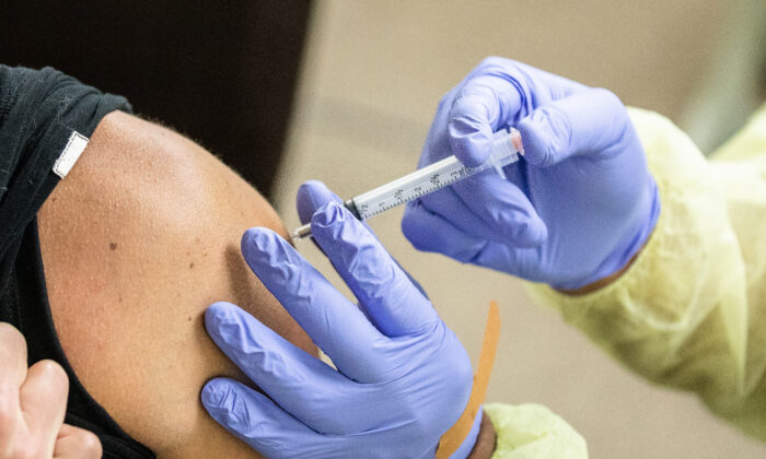 Una voluntaria administra la vacuna contra el coronavirus de Moderna a un socorrista en Orange (California) el 9 de marzo de 2021. (John Fredricks/The Epoch Times)