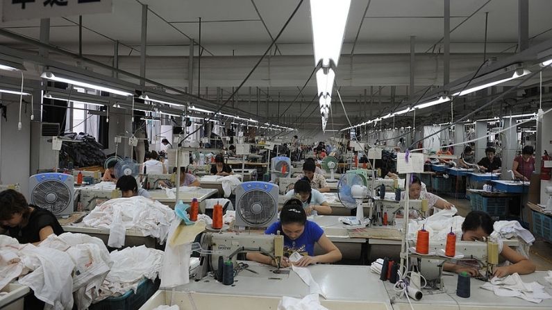 Empleados trabajan en una fábrica de prendas de vestir que suministra equipos originales (OEM) a empresas estadounidenses y europeas el 24 de junio de 2008 en Hangzhou, provincia de Zhejiang, China. (China Photos/Getty Images)