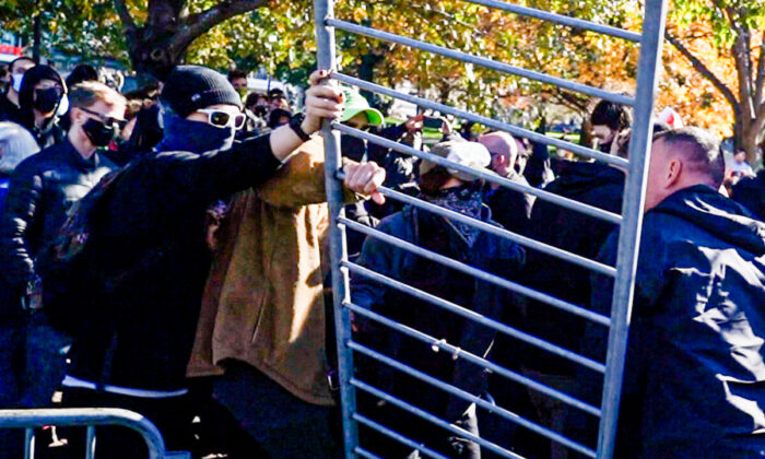 Unos manifestantes antifascistas retiraron las vallas policiales. Los dos grupos tuvieron breves enfrentamientos. (Learner Liu/The Epoch Times)