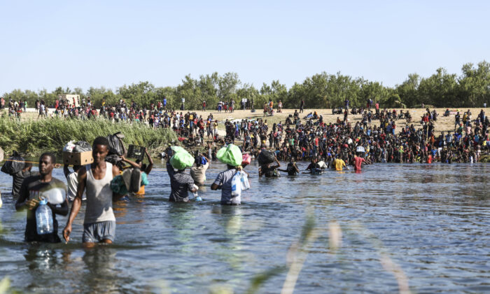 Inmigrantes ilegales cruzan el Río Bravo, entre Del Rio, Texas (lado opuesto), y Acuña, México, el 20 de septiembre de 2021. (Charlotte Cuthbertson/The Epoch Times)