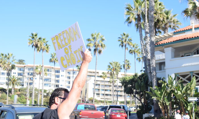 Padres e hijos se reunieron en el muelle de San Clemente para una protesta contra la orden de vacunación para COVID-19 de California a los estudiantes de K-12, en San Clemente, California, el 15 de noviembre de 2021. (Brandon Drey/The Epoch Times)