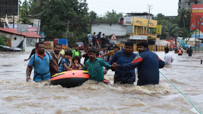 Voluntarios indios y personal de rescate evacuan a los residentes locales en un bote en una zona residencial en Aluva en el distrito de Ernakulam, en el estado hindú de Kerala el 17 de agosto de 2018. (AFP via Getty Images)