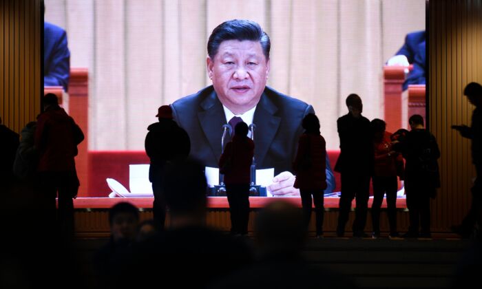 La gente camina por delante de una pantalla que muestra imágenes de vídeo del líder chino Xi Jinping en el Museo Nacional de China en Beijing el 27 de febrero de 2019. (Wang Zhao/AFP vía Getty Images)