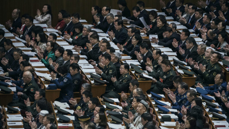 Los delegados aplauden durante la tercera sesión plenaria de la legislatura títere China (la Asamblea Popular Nacional), en El Gran Salón del Pueblo, en Beijing, el 12 de marzo de 2019. (Kevin Frayer/Getty Images)