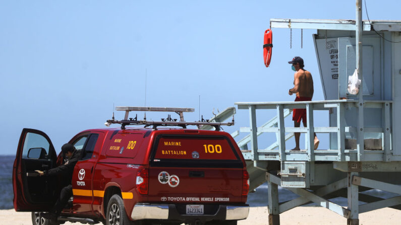 Un salvavidas usa una mascarilla en la playa de Santa Mónica el día que el condado de Los Ángeles reabrió sus playas, que habían sido cerradas debido a la pandemia de coronavirus, el 13 de mayo de 2020, en Santa Mónica, California. (Mario Tama/Getty Images)