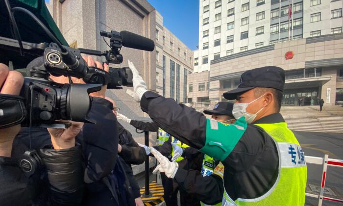 La policía trata de impedir que los periodistas graben imágenes fuera del Tribunal Popular del Nuevo Distrito de Pudong en Shanghai (China) el 28 de diciembre de 2020. (Leo Ramirez/AFP vía Getty Images)
