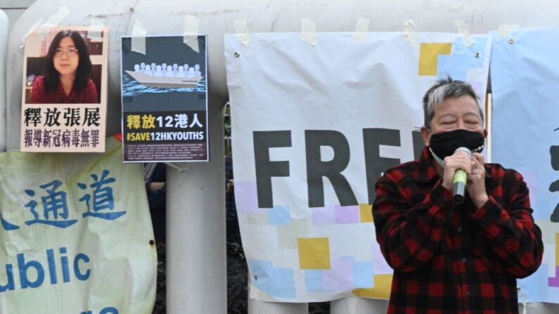 El activista democrático Lee Cheuk-Yan habla frente a la Oficina de Enlace de China en Hong Kong el 28 de diciembre de 2020, durante una protesta en la que se pide a China que libere a un grupo de activistas democráticos de Hong Kong que se enfrentan a un juicio en China, después de que intentaran huir del territorio en lancha rápida hacia Taiwán el pasado mes de agosto, así como a la periodista ciudadana china Zhang Zhan (cartel superior de la izquierda), que fue encarcelada durante cuatro años por su reportaje en livestream desde Wuhan mientras se desarrollaba el brote de covid-19. (Peter Parks/AFP vía Getty Images)