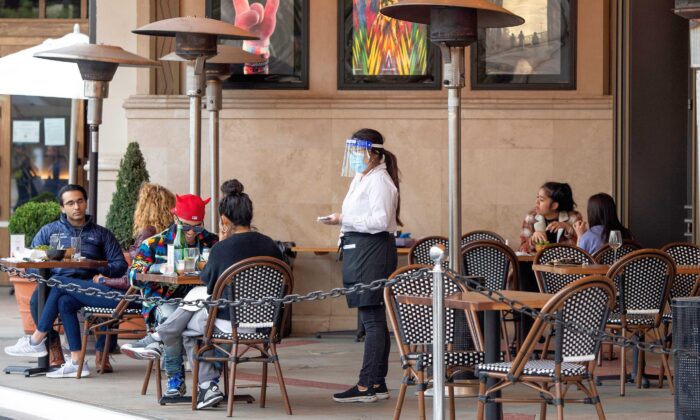 Una camarera toma los pedidos de los clientes en la zona al aire libre de un restaurante en Los Ángeles, California, el 28 de enero de 2021. (Valerie Macon/AFP vía Getty Images)