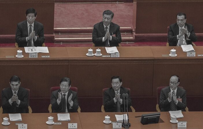 El líder chino Xi Jinping, arriba en el centro, el primer ministro Li Keqiang, a la derecha, y el presidente del CNP Li Zhanshu aplauden durante un discurso en la segunda sesión plenaria en el Gran Salón del Pueblo en Beijing, China, el 8 de marzo de 2021. (Kevin Frayer/Getty Images)