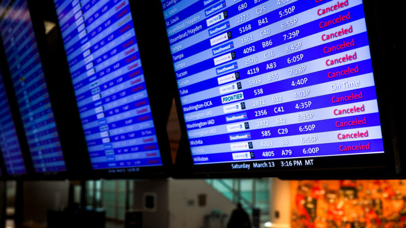Un hombre pasa junto a un tablero de anuncios que muestra la mayoría de los vuelos cancelados en el Aeropuerto Internacional de Denver (Colorado) el 13 de marzo de 2021. (Michael Ciaglo/Getty Images)