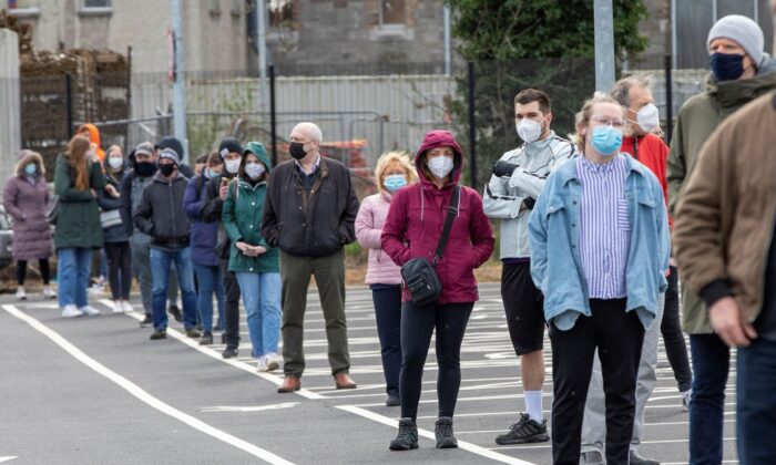 La gente espera en una fila para recibir una prueba de hisopo para detectar la COVID-19 en un centro de pruebas portátil sin cita previa operado por el servicio ambulatorio en Dublín (Irlanda) el 25 de marzo de 2021. (Paul Faith/AFP a través de Getty Images)
