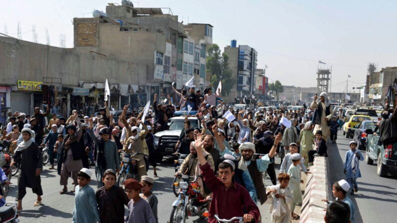 Simpatizantes de los talibanes gritan eslóganes y ondean banderas talibanes mientras marchan por una calle de Kandahar el 31 de agosto de 2021. (-/AFP vía Getty Images)