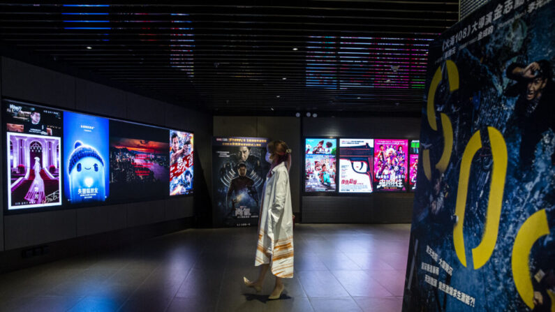 Esta foto tomada el 2 de septiembre de 2021 muestra a una mujer mirando los anuncios de películas en un cine de Hong Kong. La industria cinematográfica de Hong Kong, antaño famosa por su cine de primera categoría, debe enfrentarse a un nuevo obstáculo: los controles de censura al estilo de China continental, ya que las autoridades llevan su purga de la disidencia a la esfera cultural. (Isaac Lawrence/AFP vía Getty Images)