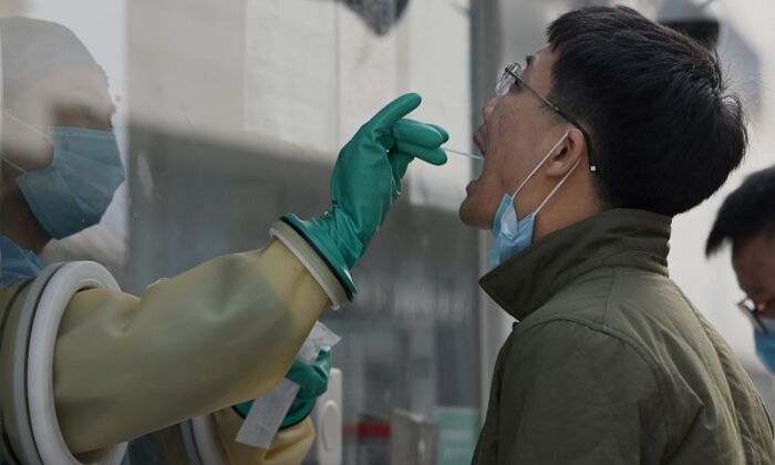 Un trabajador de la salud toma una muestra de COVID-19 en una estación de pruebas en Beijing, China, el 25 de octubre de 2021. (Noel Celis/AFP vía Getty Images)
