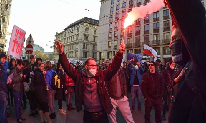 Los manifestantes encienden bengalas durante un mitin organizado por el Partido de la Libertad de Austria contra las restricciones por  COVID-19 en Viena, Austria, el 20 de noviembre de 2021. (Joe Klamar/AFP a través de Getty Images)