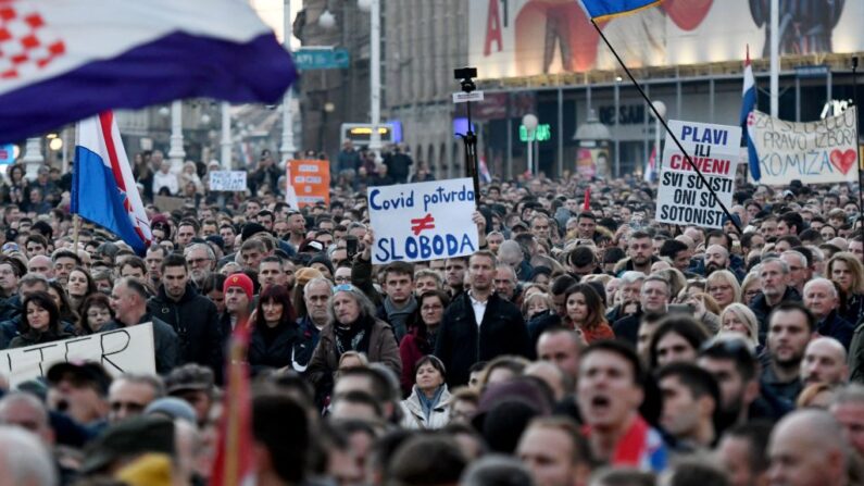 Manifestantes marchan con pancartas en el centro de Zagreb (Croacia) para protestar contra las medidas de covid-19, como los certificados obligatorios para el sector público, el 20 de noviembre de 2021. (Denis Lovrovic/AFP vía Getty Images)