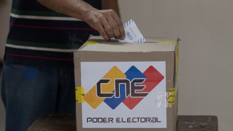 Una persona deposita su voto en un colegio electoral en Caracas, durante las elecciones regionales y municipales en Venezuela, el 21 de noviembre de 2021. (Federico Parra/AFP vía Getty Images)