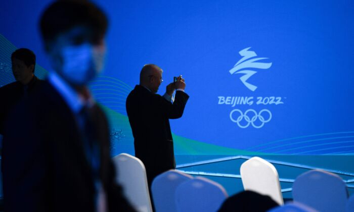 Un hombre toma fotografías de un logotipo de los Juegos Olímpicos de Invierno de Beijing 2022 durante el evento de conteo regresivo de los Juegos Paralímpicos de Invierno de Beijing 2022 en el Centro Acuático Nacional en Beijing, el 24 de noviembre de 2021. (Wang Zhao/AFP a través de Getty Images)