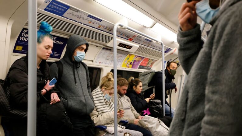 Viajeros, algunos con la cara cubierta debido a la pandemia de covid-19, viajan en un vagón de la línea Jubilee de Transport for London (TfL) hacia el centro de Londres (Reino Unido) el 26 de noviembre de 2021. (Tolga Akmen/AFP vía Getty Images)