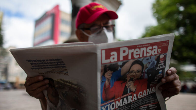 Un hombre lee un periódico local que anuncia a Xiomara Castro como ganadora de las elecciones generales el 29 de noviembre de 2021 en Tegucigalpa, Honduras. (Inti Ocon/Getty Images)