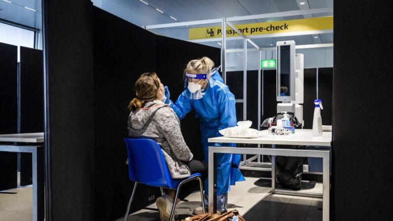 Los viajeros procedentes de Sudáfrica se someten a la prueba del covid-19 a su llegada en una calle de pruebas especialmente diseñada en el aeropuerto de Schiphol (Países Bajos), el 30 de noviembre de 2021. (Remko de Waal / ANP / AFP vía Getty Images)