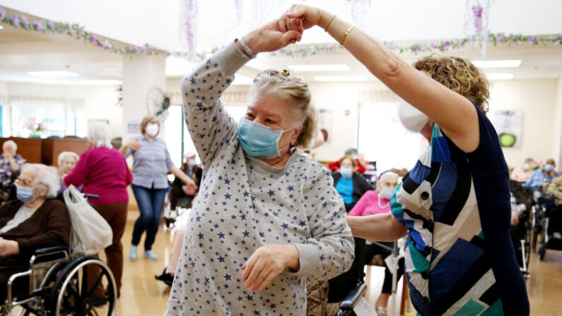 Residentes y personal se reúnen y bailan durante un concierto de Pascua para residentes vacunados en el Centro de Enfermería Ararat, en el vecindario de Mission Hills, el 1 de abril de 2021, en Los Ángeles, California. (Mario Tama/Getty Images)
