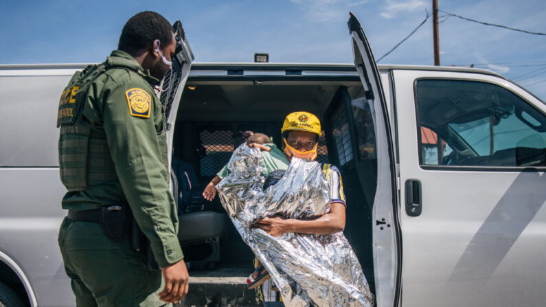 Una mujer migrante con un niño sale de una camioneta de la Patrulla Fronteriza después de llegar a las instalaciones de la Coalición Humanitaria Val Verde el 22 de septiembre de 2021 en Del Río, Texas. (Brandon Bell/Getty Images)