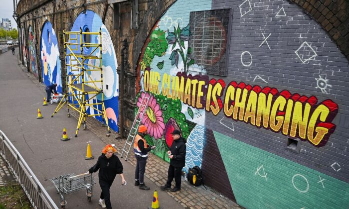 Artistas pintan murales en una pared cerca del Scottish Event Campus en Glasgow, Escocia, el 13 de octubre de 2021, donde se celebrará la 26ª Conferencia de las Naciones Unidas sobre el Cambio Climático entre el 31 de octubre al 12 de noviembre. (Jeff J. Mitchell/Getty Images)