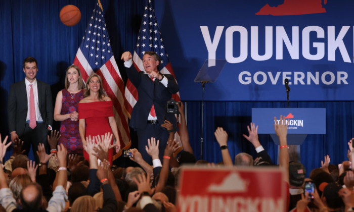 El candidato republicano a gobernador de Virginia, Glenn Youngkin, estando acompañado de su familia lanza una pelota de baloncesto autografiada a la multitud en un mitin la noche de las eleciones estatales en el Westfields Marriott Washington Dulles de Chantilly, Virginia, el 2 de noviembre de 2021. (Chip Somodevilla/Getty Images)