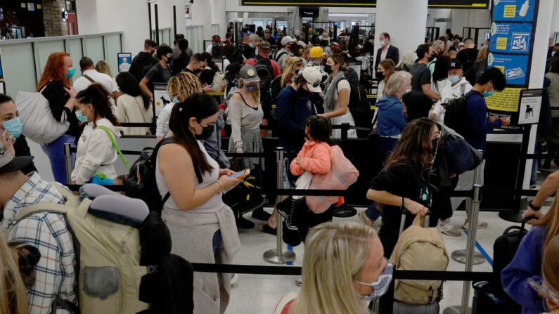 La gente espera en la fila para pasar por el punto de control de la TSA en el Aeropuerto Internacional de Miami el 24 de noviembre de 2021 en Miami, Florida. (Joe Raedle/Getty Images)