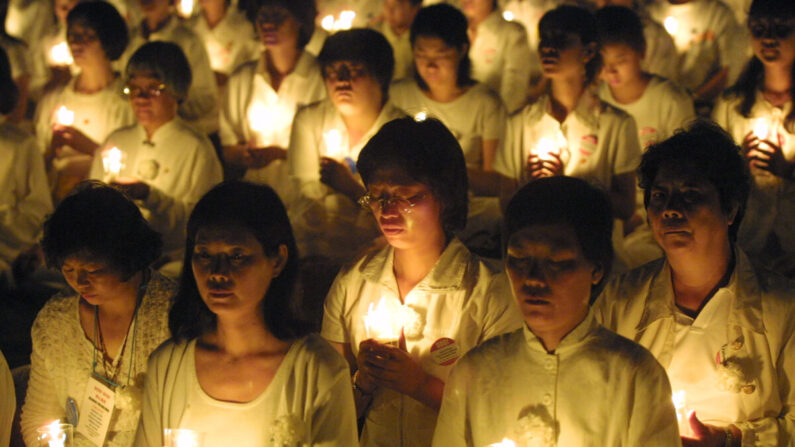 Practicantes de Falun Gong celebran una vigilia con velas para rendir homenaje a las vidas de aquellos que en China han sido golpeados y torturados hasta la muerte, en Washington, DC, el 19 de julio de 2001. (Alex Wong/Getty Images)