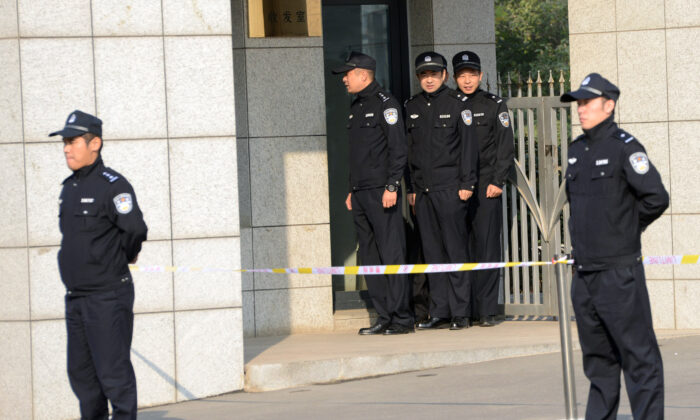 La policía china vigila la puerta afuera del edificio del tribunal superior de Shandong en Jinan, provincia de Shandong, en el este de China, el 25 de octubre de 2013. (Goh Chai Hin/AFP a través de Getty Images)