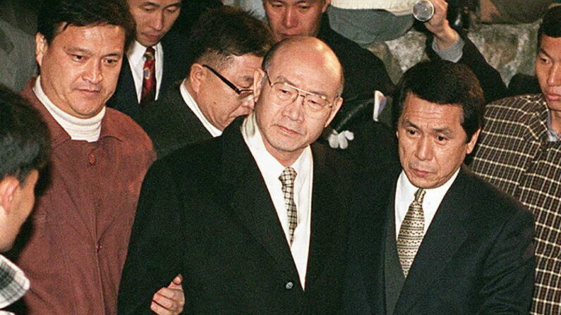 El expresidente surcoreano Chun Doo-Hwan (c) es detenido por las autoridades de la fiscalía en la casa de un familiar en Hapchon, Corea del Sur, el 3 de diciembre de 1995. (Kim Jae-Hwan/AFP vía Getty Images)