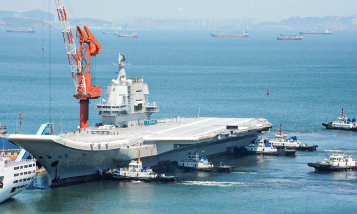Esta foto, tomada el 18 de mayo de 2018, muestra remolcadores que guían al primer portaaviones de fabricación nacional de China, conocido como "Tipo 001A", cuando regresa al puerto de Dalian, en la provincia nororiental china de Liaoning, después de su primera prueba en el mar. (AFP a través de Getty Images)