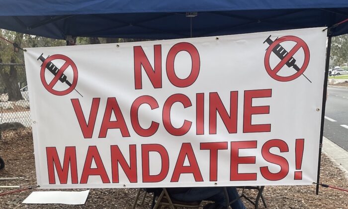 Empleados del Laboratorio de Propulsión a Chorro (JPL), un centro de campo de la NASA, cuelgan un cartel en protesta por la orden federal de vacunación contra COVID-19 en Pasadena, California, el 1 de noviembre de 2021. (Alice Sun/The Epoch Times)