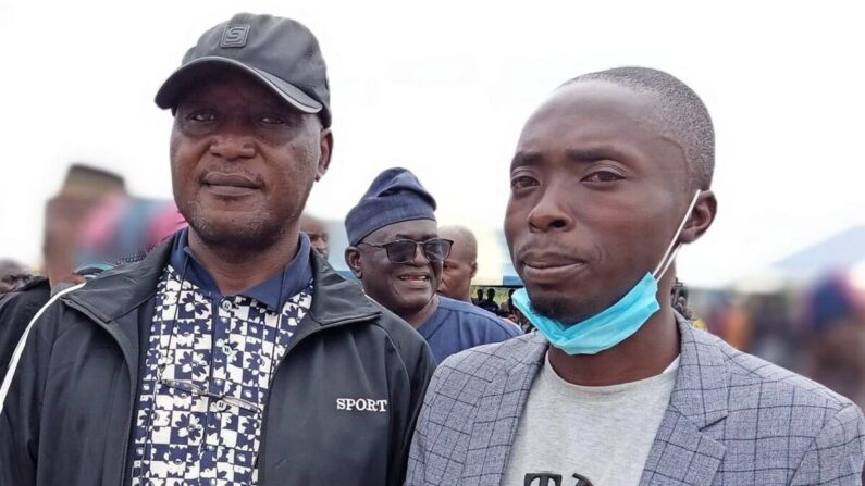 Luka Binniyat, izq. y Lawrence Zongo, der., colaboradores de The Epoch Times, de pie en un entierro masivo para las víctimas de la masacre del pueblo de Madamai, cerca de Madamai, Nigeria, el 30 de septiembre de 2021 (Bitrus Adamu).