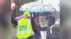 Alumno de 5º grado ve a una guardia de cruce escolar bajo la lluvia y le sostiene un paraguas