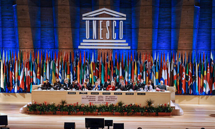 La directora general de la UNESCO, la búlgara Irina Bokova (primera fila, centro, de azul), flanqueada por la presidenta del Consejo Ejecutivo, la rusa Eleonora Valentinovna Mitrofanova (i), y la presidenta de la 36ª sesión, la húngara Katalina Bogyay (dcha.), regula la votación para que los palestinos entren en la UNESCO como miembros de pleno derecho el 31 de octubre de 2011 en la sede de la organización en París. (MIGUEL MEDINA/AFP vía Getty Images)