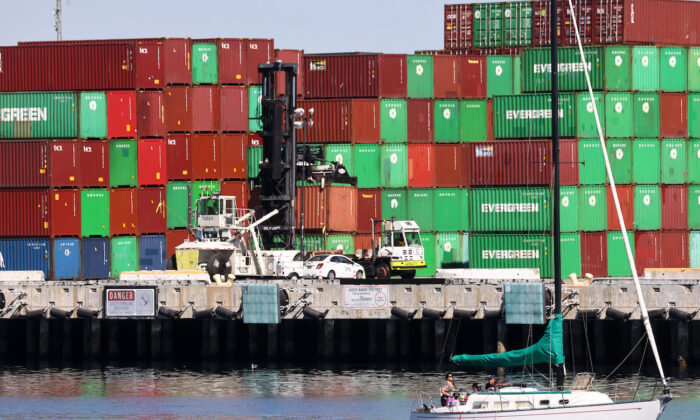 Un velero pasa junto a contenedores de carga apilados en el Puerto de Los Ángeles, el puerto de contenedores más activo de Estados Unidos, en San Pedro, California, el 15 de octubre de 2021. (Mario Tama/Getty Images)